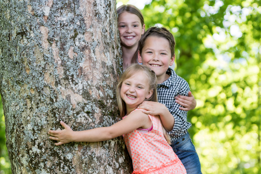 Kinder umarmen Baum